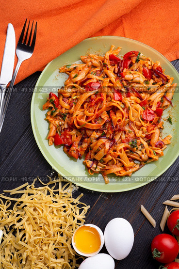  italian pasta with tomatos and herbs on dark wooden table. flat lay. Стоковое фото, агентство Ingram Publishing / Фотобанк Лори