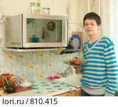 Юноша собирается разогреть еду в микроволновке (2009 год). Редакционное фото, фотограф Ирина Солошенко / Фотобанк Лори