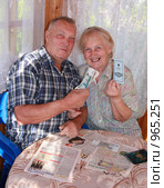Пожилые мужчина и женщина с деньгами и сберкнижкой (2009 год). Редакционное фото, фотограф GANG / Фотобанк Лори