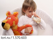Маленькая девочка пьет из бутылочки молочную смесь (2010 год). Редакционное фото, фотограф Наталья Белотелова / Фотобанк Лори