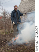 Мужчина жжет мусор на садовом участке (2010 год). Редакционное фото, фотограф Сергей Дубров / Фотобанк Лори