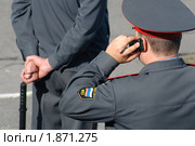 Милиционер разговаривает по мобильному телефону на фоне милиционера с дубинкой. Стоковое фото, фотограф Вячеслав Палес / Фотобанк Лори