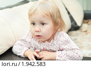 Маленькая девочка сидит на диване, увлеченно смотрит вперед. Стоковое фото, фотограф Кекяляйнен Андрей / Фотобанк Лори