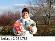 Женщина держит в руках атлас мира, заграничный паспорт и деньги. Стоковое фото, фотограф Ольга Линевская / Фотобанк Лори