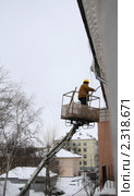 Рабочий сбивает сосульки и очищает крышу от снега (2011 год). Редакционное фото, фотограф Alechandro / Фотобанк Лори