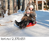 Счастливая семья.(Радостные мама с сыном едут с горки зимой на таблетке) (2011 год). Редакционное фото, фотограф Игорь Низов / Фотобанк Лори