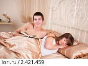 Юноша читает книгу, рядом с ним спит девушка. Стоковое фото, фотограф Валерия Лузина / Фотобанк Лори