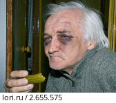 Мужчина с двумя синяками закусывает солёным огурчиком. Стоковое фото, фотограф Владимир Макеев / Фотобанк Лори