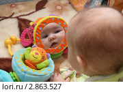 Четырёхмесячная девочка смотрится в игрушечное зеркало. Стоковое фото, фотограф Григорий Писоцкий / Фотобанк Лори