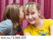 Девочка рассказывает шепотом свой секрет подружке на ухо (2011 год). Редакционное фото, фотограф Игорь Низов / Фотобанк Лори
