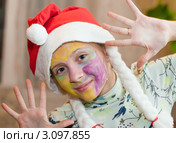 Весёлая девочка  в новогоднем колпаке с разрисованным лицом красками. Стоковое фото, фотограф Игорь Низов / Фотобанк Лори