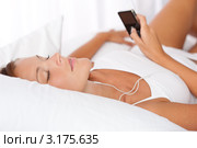 Симпатичная девушка в наушниках слушает музыку через mp3-плеер. Стоковое фото, фотограф CandyBox Images / Фотобанк Лори