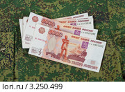 Денежные купюры лежат на новой форме одежды  военнослужащего. Стоковое фото, фотограф FotograFF / Фотобанк Лори