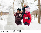 Три девочки строят снеговика (2012 год). Редакционное фото, фотограф Игорь Низов / Фотобанк Лори