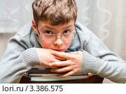 Уставший мальчик сидит на стуле  со стопкой книг. Стоковое фото, фотограф Игорь Низов / Фотобанк Лори