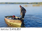 Рыбак выгружает улов сырка (пеляди) из лодки (2011 год). Редакционное фото, фотограф Галина Хорошман / Фотобанк Лори