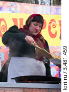 Женщина на Масленицу жарит и подаёт блины (2012 год). Редакционное фото, фотограф Олег Велигданов / Фотобанк Лори