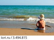 Маленькая девочка сидит на песчаном пляже у моря. Стоковое фото, фотограф Емельянова Карина / Фотобанк Лори
