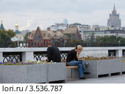 Молодая пара читает на уличной скамейке (2009 год). Редакционное фото, фотограф Юрий Синицын / Фотобанк Лори