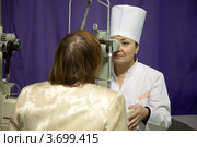 Женщина окулист исследует зрение у пожилой пациентки. Стоковое фото, фотограф Яков Филимонов / Фотобанк Лори