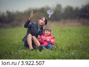 Мама с дочкой запускают бумажный самолетик на лугу. Стоковое фото, фотограф Наталья Чуб / Фотобанк Лори