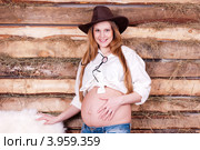 Беременная в ковбойской шляпе на фоне стены из досок. Стоковое фото, фотограф Охотникова Екатерина *Фототуристы* / Фотобанк Лори