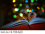 Страницы книги в форме сердечка на фоне разноцветных огней. Стоковое фото, фотограф Ольга Денисова / Фотобанк Лори
