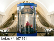 Работница метрополитена, наблюдающая за эскалаторами. Станция метро "Международная". Санкт-Петербург (2012 год). Редакционное фото, фотограф Ольга Визави / Фотобанк Лори
