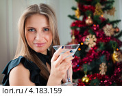 Красивая девушка с бокалом шампанского на фоне ёлки. Стоковое фото, фотограф Игорь Низов / Фотобанк Лори