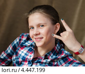 Весёлая девочка подросток показывает два пальца левой руки. Стоковое фото, фотограф Игорь Низов / Фотобанк Лори