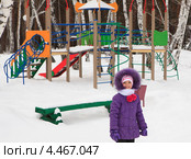 Маленькая девочка на фоне детской площадки в зимнем лесу (2013 год). Стоковое фото, фотограф Юлия Машкова / Фотобанк Лори
