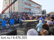 Сковорода снимается с огня при помощи подъемного крана. Масленица в Ялуторовске (2013 год). Редакционное фото, фотограф Анатолий Матвейчук / Фотобанк Лори