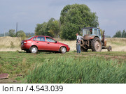 Трактор "Белорус" взял на буксир "Ладу Калину" (2007 год). Редакционное фото, фотограф Dmitry29 / Фотобанк Лори