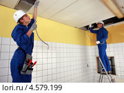 Электрики работают в помещении. Стоковое фото, фотограф Phovoir Images / Фотобанк Лори