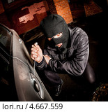 Автомобильный вор вскрывает дверь у машины. Стоковое фото, фотограф Андрей Армягов / Фотобанк Лори
