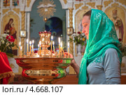 Девушка в платке ставит свечку в православном храме. Стоковое фото, фотограф Андрей Ярославцев / Фотобанк Лори