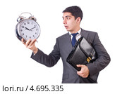 Деловой мужчина с портфелем подмышкой удивленно смотрит на будильник в руке. Стоковое фото, фотограф Elnur / Фотобанк Лори