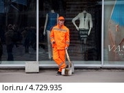 Дворник азиатской внешности на фоне витрины с манекенами в центре Москвы (2013 год). Редакционное фото, фотограф Николай Винокуров / Фотобанк Лори
