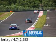 Автомобили соревнуются на Чемпионате мира по шоссейно-кольцевым гонкам FIA WTCC среди легковых автомобилей на трассе Moscow Raceway в Подмосковье (2013 год). Редакционное фото, фотограф Николай Винокуров / Фотобанк Лори