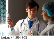 Коллеги-врачи у светящегося экрана с томографическими снимками больного. Стоковое фото, фотограф Sergey Nivens / Фотобанк Лори