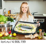 Улыбающаяся девушка  держит противень с рыбой и картофелем. Стоковое фото, фотограф Яков Филимонов / Фотобанк Лори
