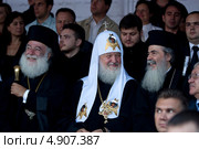 Святейший Патриарх Федор II, Кирилл и Феофил III смеются на трибуне для зрителей концерта, посвященного 1025-летию Крещения Руси на Красной площади в городе Москве, Россия (2013 год). Редакционное фото, фотограф Николай Винокуров / Фотобанк Лори