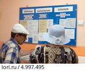 Люди у стенда паспортного стола (2013 год). Редакционное фото, фотограф Вячеслав Палес / Фотобанк Лори
