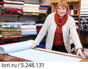 Пожилая продавщица отмеряет ткань. Стоковое фото, фотограф Яков Филимонов / Фотобанк Лори