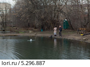Мужчина и женщина на пруду вываживают пойманную рыбу. Стоковое фото, фотограф Михаил Иванов / Фотобанк Лори