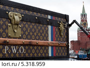 Демонтаж скандальной рекламной конструкции в виде чемодана "Louis Vuitton" на Красной площади на фоне Спасской башни Московского кремля (2013 год). Редакционное фото, фотограф Николай Винокуров / Фотобанк Лори