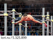 Спортсмен выполняет упражнения на чемпионате мира Street Workout World Cup 2013 Super Final в Москве. Редакционное фото, фотограф Николай Винокуров / Фотобанк Лори