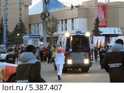 Факелоносец бежит за автомобилем с осветителями. Тюмень (2013 год). Редакционное фото, фотограф Анатолий Матвейчук / Фотобанк Лори