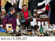 Продавец за прилавком на блошином рынке. Франкфурт-на-Майне, Германия (2009 год). Редакционное фото, фотограф Людмила Угольнова / Фотобанк Лори