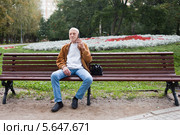 Пожилой мужчина разговаривает по телефону на лавочке в парке. Стоковое фото, фотограф Victoria Demidova / Фотобанк Лори